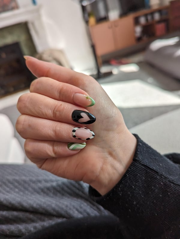 Picture by gingerchel saying 'Mismatched Nails 💚 🖤 🤍'